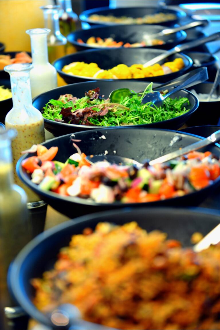 a row of woks showing prepared plant based dishes