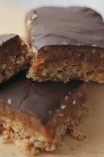 three vegan caramel slices stacked on a plate