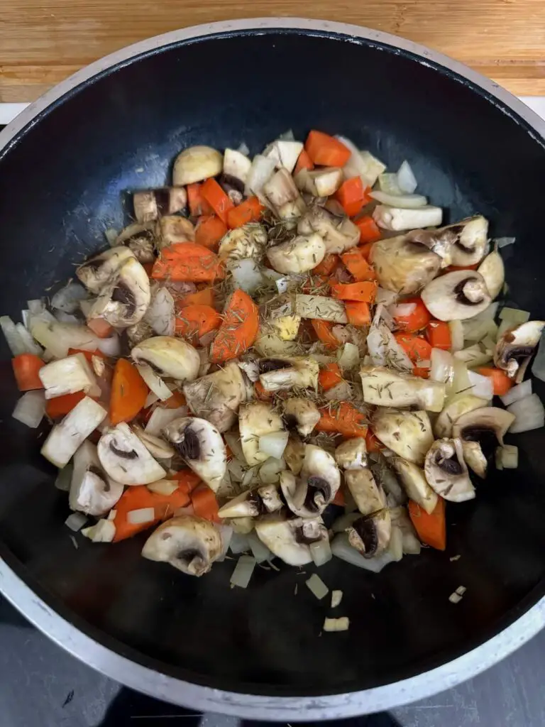 vegetables and herbs for gluten free vegan gravy cooking in a pan