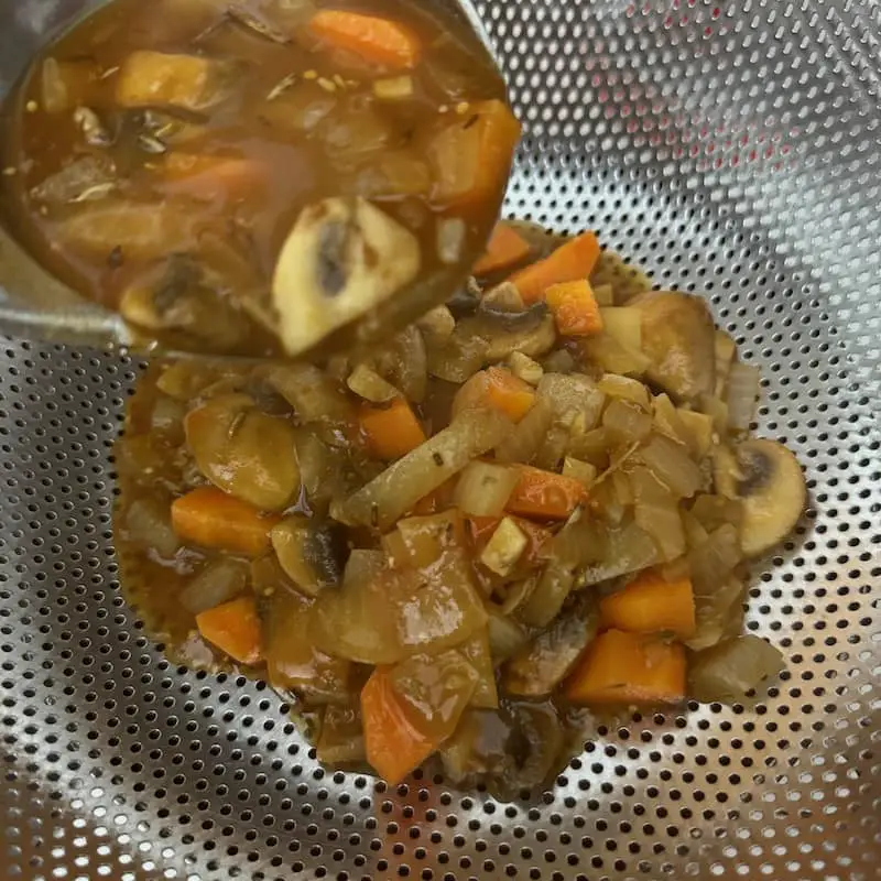 straining gluten free vegan gravy through a sieve