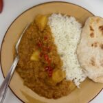 lentil and potato dahl served with rice and naan bread