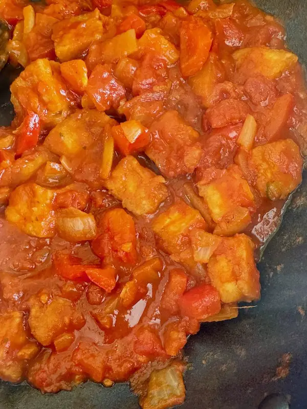 tofu in tomato sauce cooking in a pan