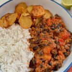 creamy black bean curry served with rice and sliced potatoes