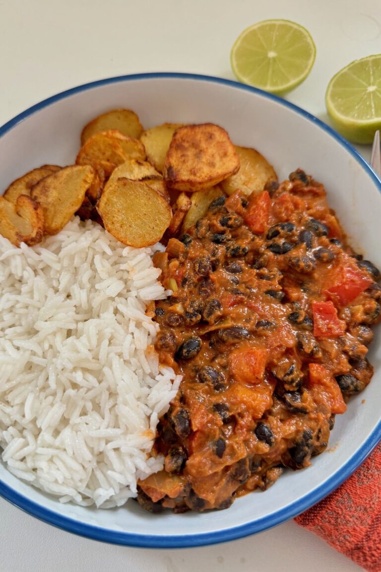 creamy black bean curry served with rice and sliced potatoes