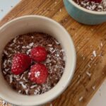 silken tofu mousse served in two ramekins with raspberries and shredded coconut