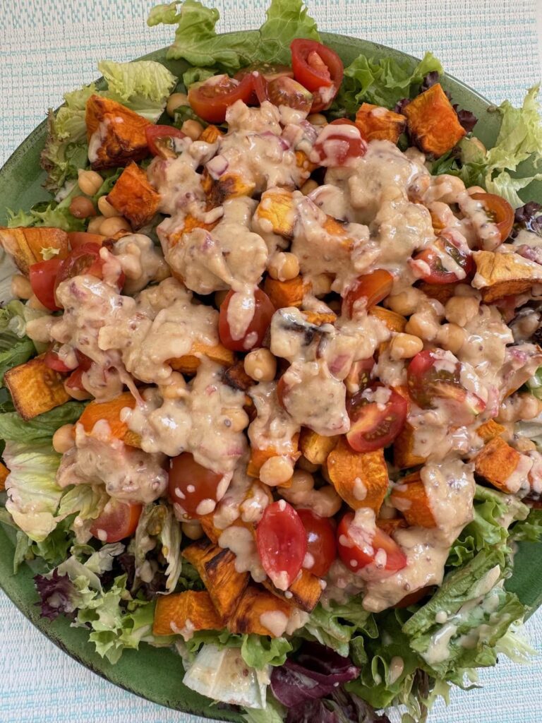 air fryer sweet potato and chickpea salad served on a large plate with dressing
