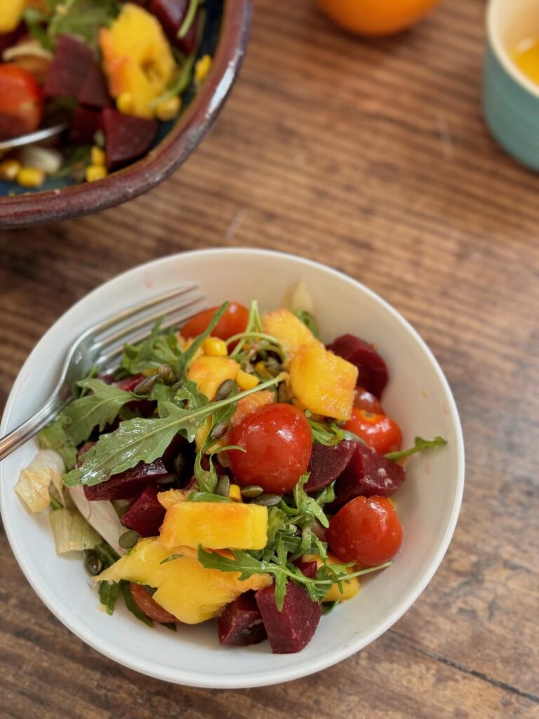mango and beet salad served in a bowl with the serving bowl in the background