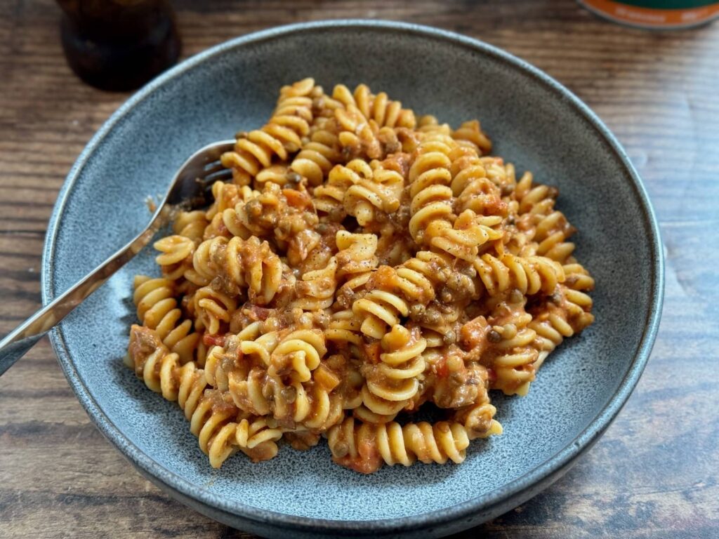 a ten minute creamy vegan pasta with lentils served in a bowl