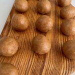 almond peanut butter balls laid out on a board