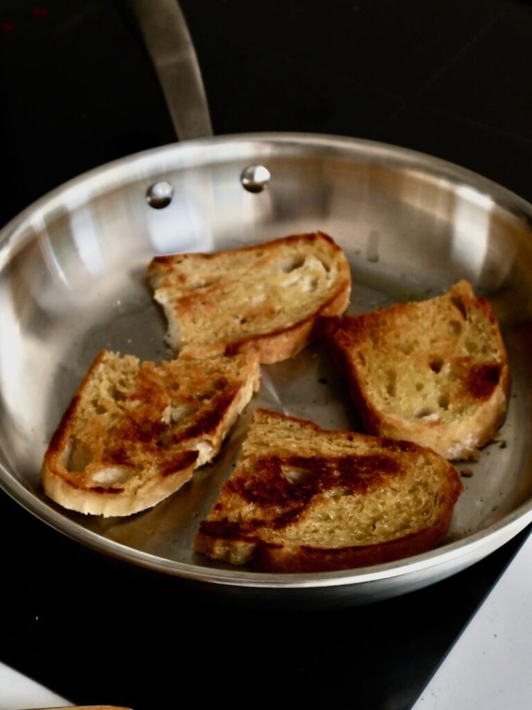 sourdough bread toasting on a pan