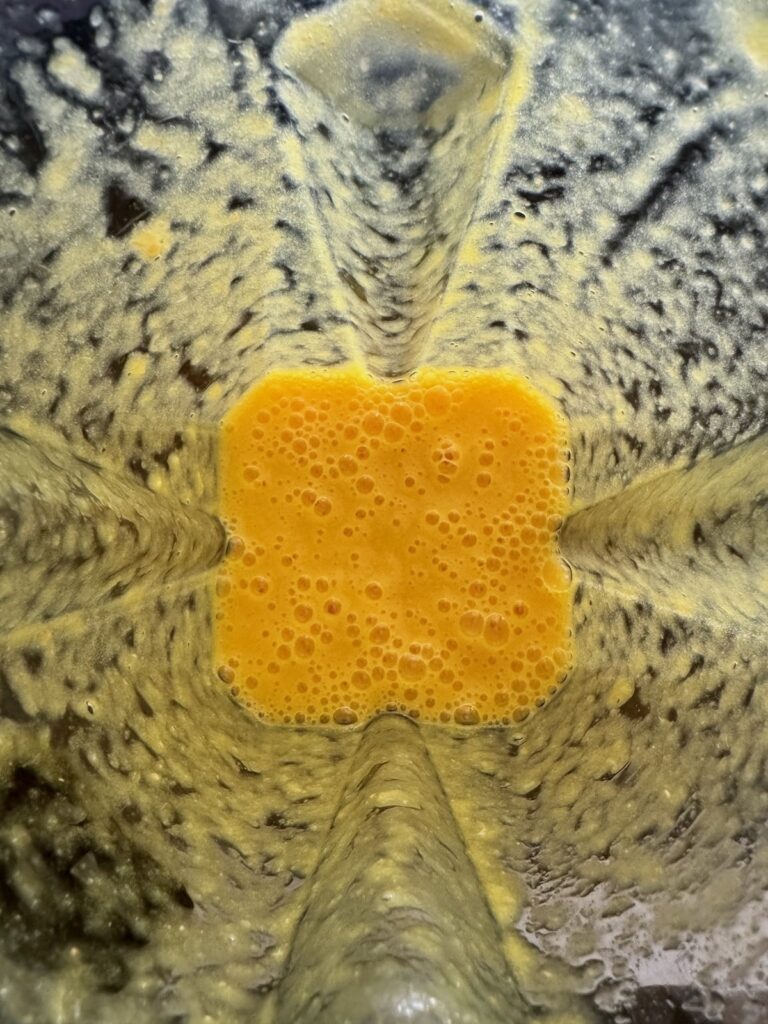 Turmeric Ginger Citrus shot ingredients mixed in a blender and viewed from above
